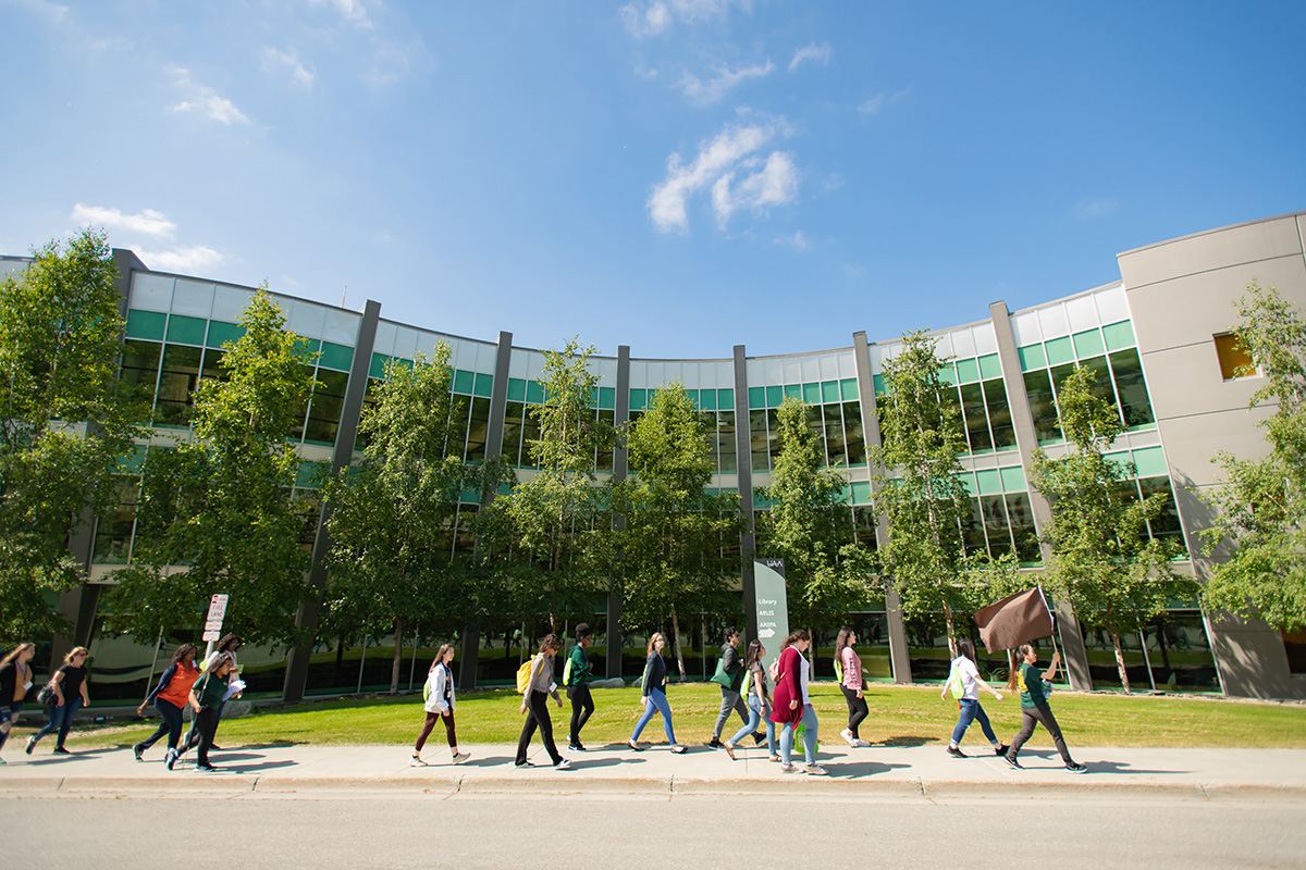 Students walk across campus outdoors at the UAA location