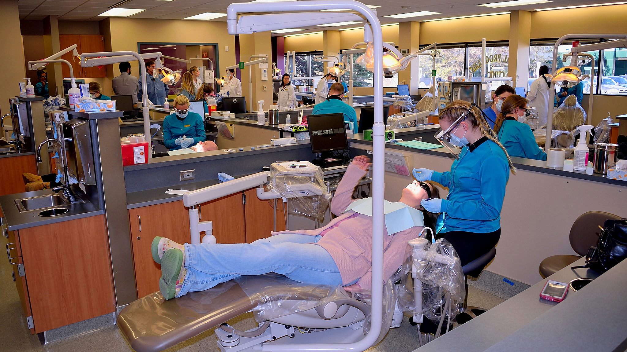 Wide shot of dental clinic with dental students working on patients