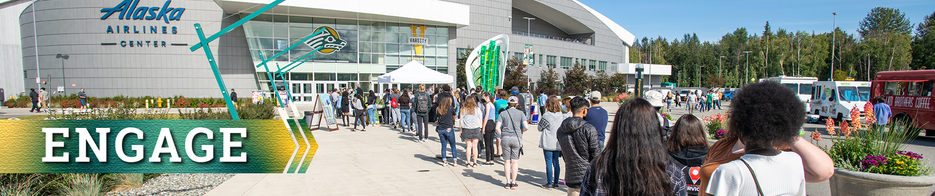 Students in a line to enter Campus Kickoff 2021 in the Alaska Airlines Center with banner that says "Engage"