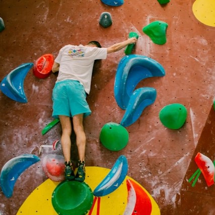 A man climbing a gym wall.