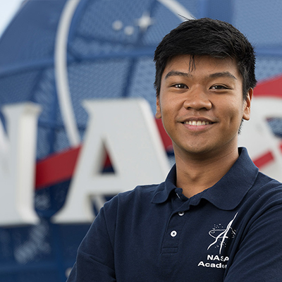 Portrait of M.E. student, Lawrence Giron Jr. in front of the NASA logo.