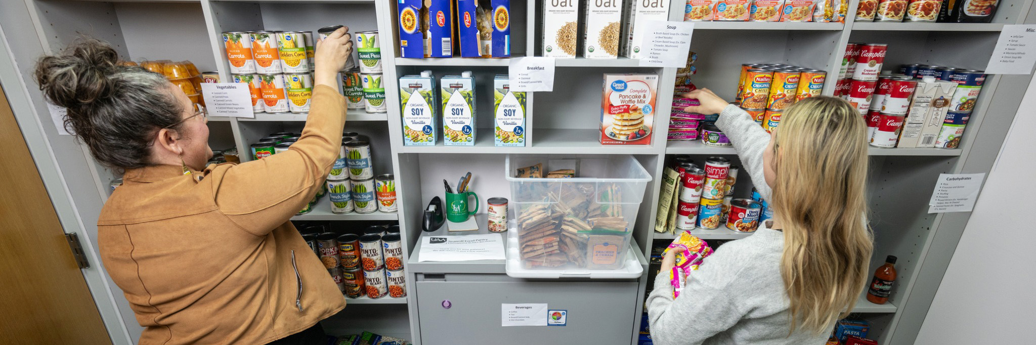 people putting food on pantry shelves