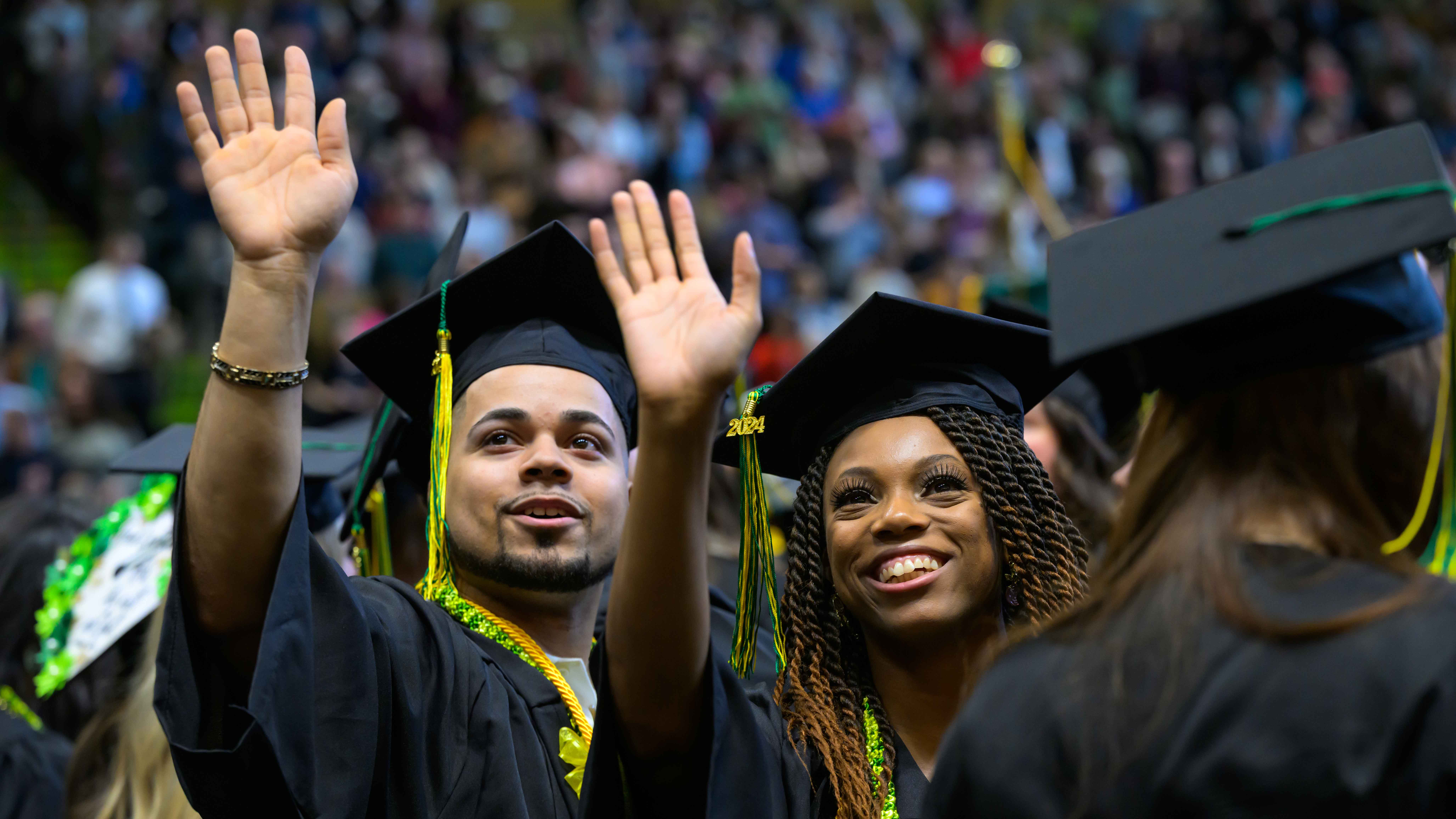 HUMS students holding diplomas and waving