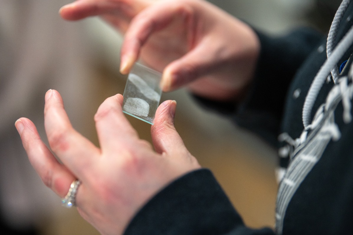 hands holding glass with fingertips 