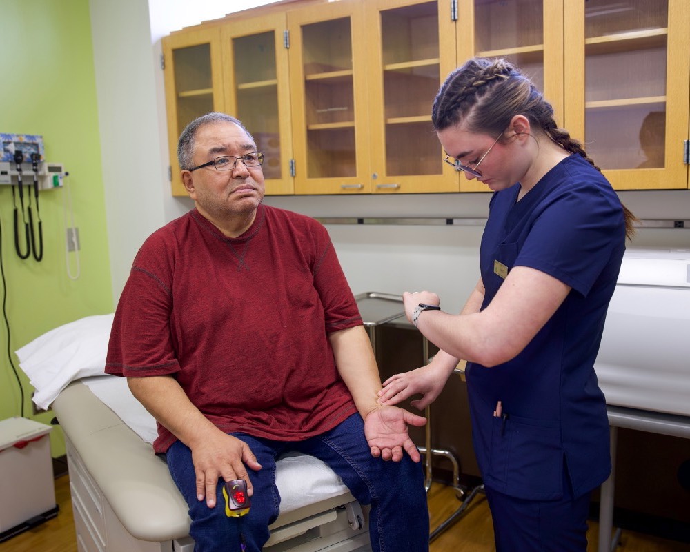 medical assisting student practices with standarized patient during simulation training