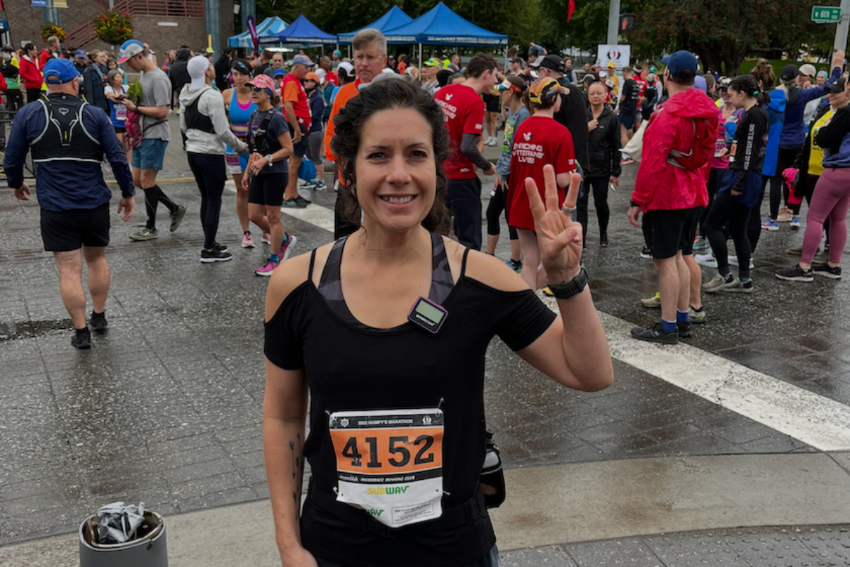 Sarah Brueckner at the Run Fest Marathon holding up 3 fingers to indicate her third marathon complete