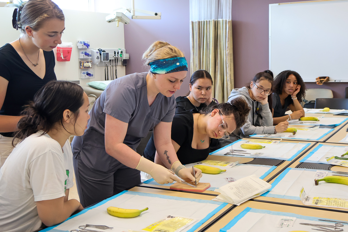 students learning how to do sutures on bananas with MedEx department 