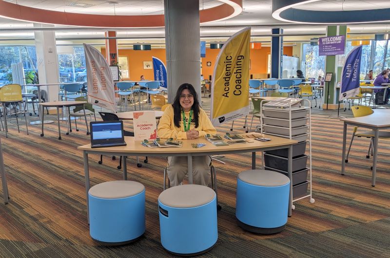 Academic Coach sits at desk smiling 