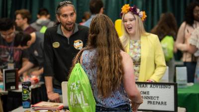 Student talks to first-year advisors at an event