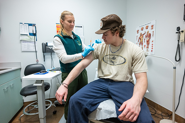 Student Teagan Dervaes receives vaccination from DNP, APRN, Family Nurse Practitioner Jordan Cannone in UAA's Student Health and Counseling Center.