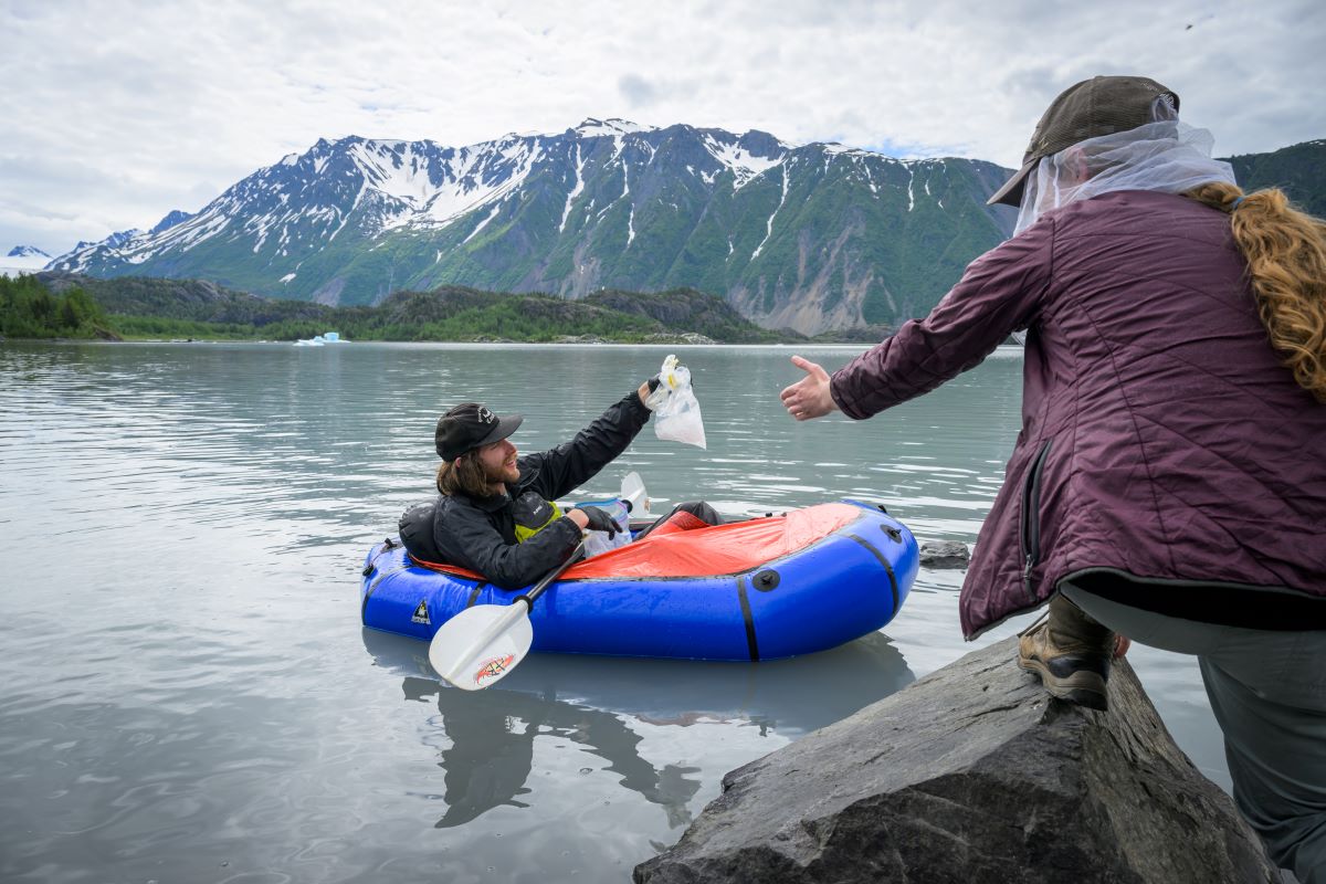 Nathaniel Beck uses a packraft to collect samples from glacial icebergs on Grewingk Glacier Lake