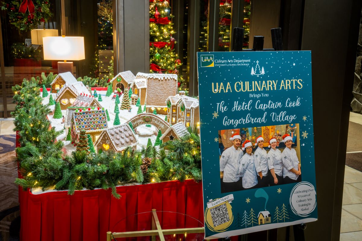 a gingerbread village display in a hotel lobby and a sign for UAA Culinary Arts