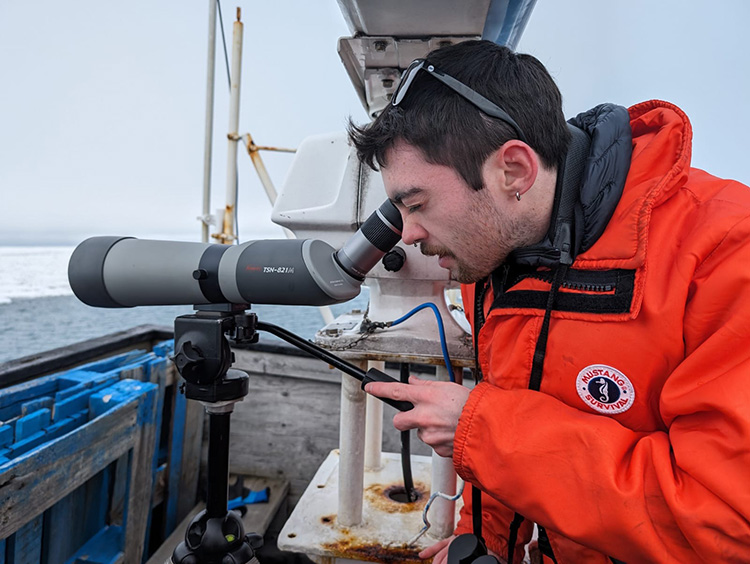 Kyle Kolda looking through a telescope