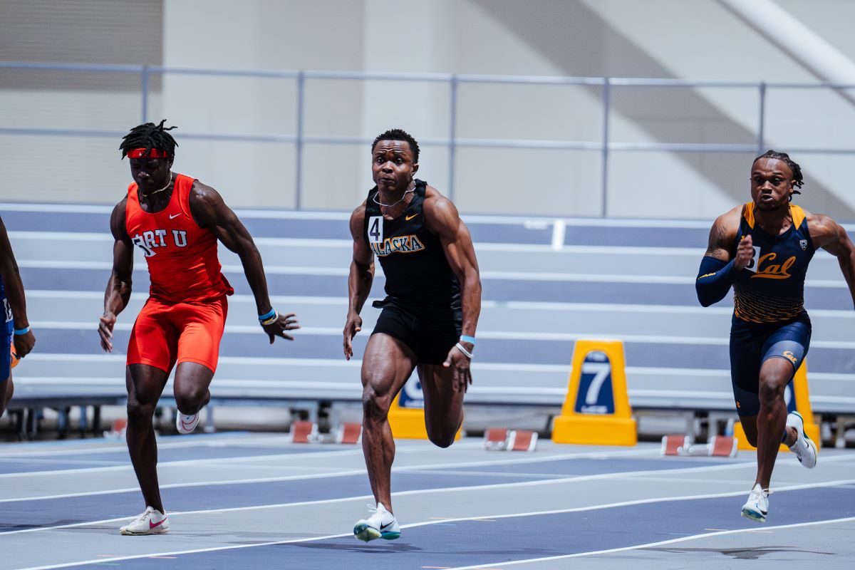 Joshua Caleb and two others running on a track